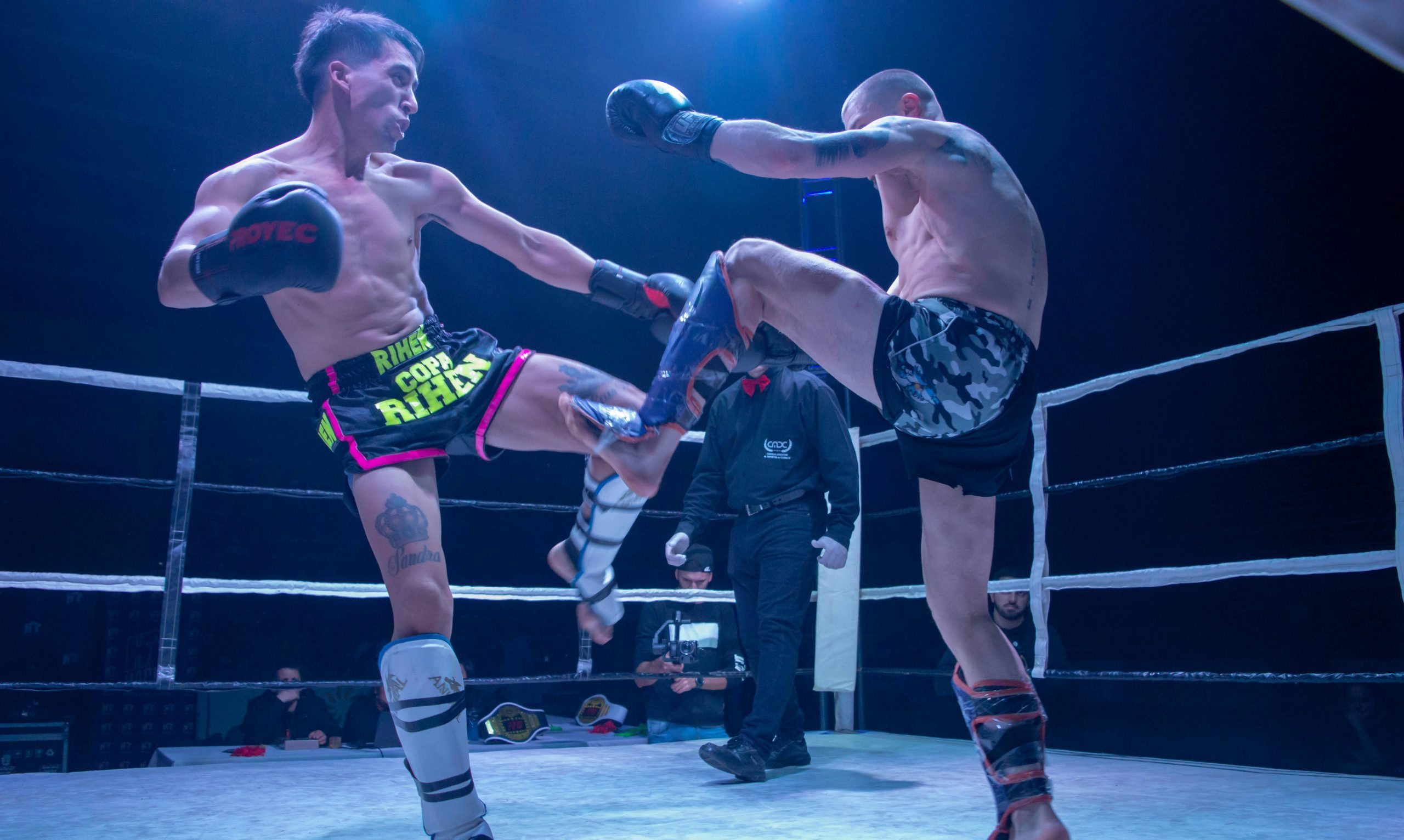 Deux combattants de boxe pieds-poings en plein échange sur un ring lors d'une compétition