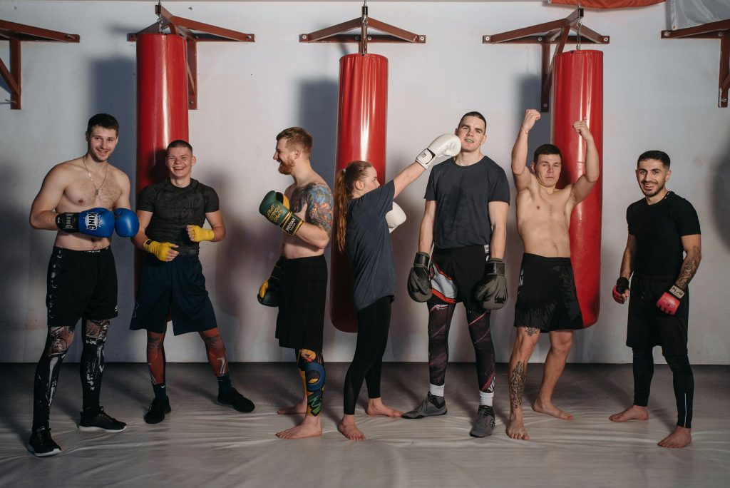Boxe sport collectif : groupe de boxeurs s'entraînant ensemble dans une salle de boxe avec sparring et coaching collectif